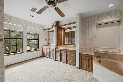 an empty room with windows and fan