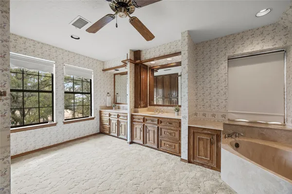 an empty room with windows and fan