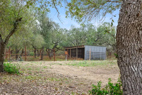 a view of a house with a backyard and a tree