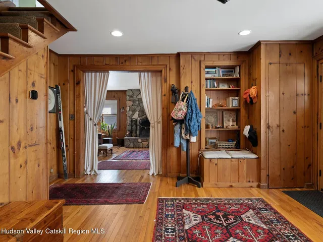 a view of a hallway with wooden floor and furniture