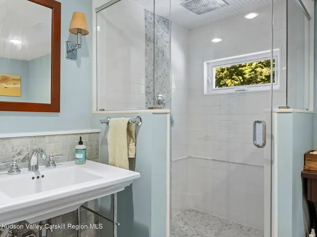 a bathroom with a sink a mirror and a shower