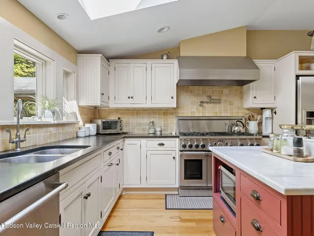 a kitchen with granite countertop a sink stainless steel appliances and cabinets