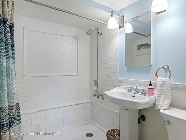 a bathroom with a sink shower and a mirror