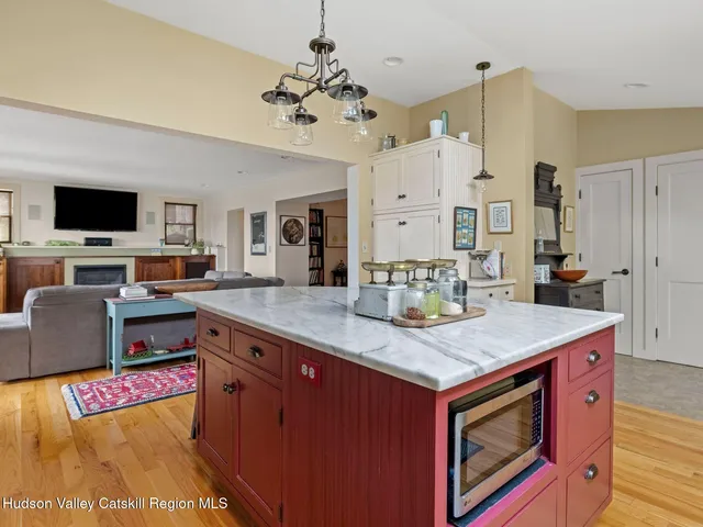 a kitchen with stainless steel appliances granite countertop a stove and a view of living room