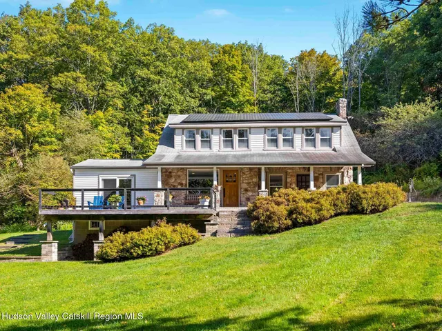 a front view of a house with a garden and trees