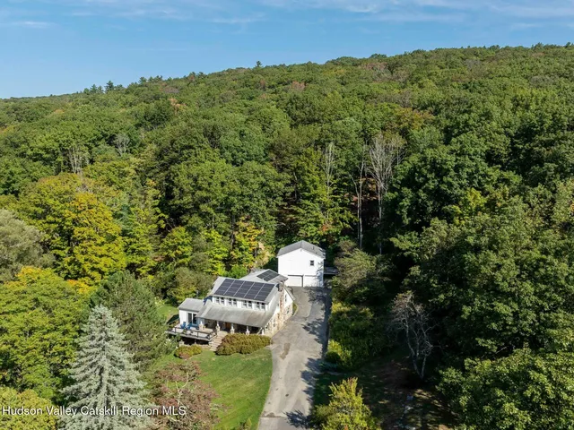 an aerial view of residential house with outdoor space and trees all around