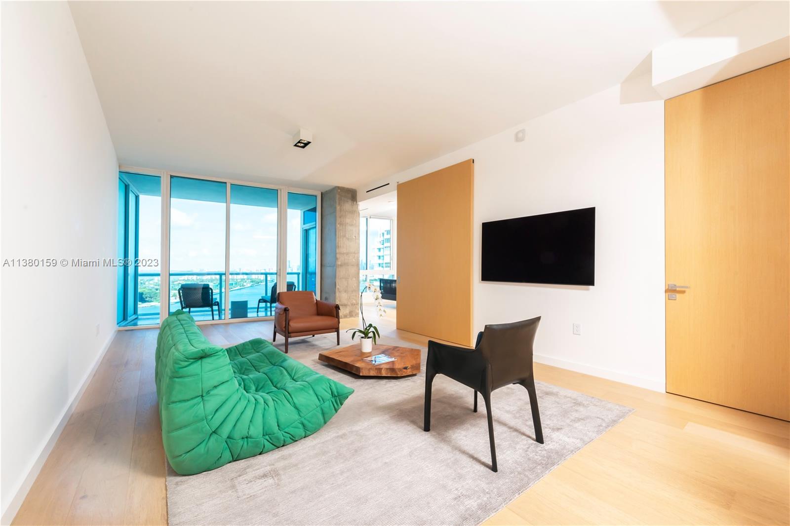 100 South Pointe Drive, Unit 1802 Miami Beach, FL 33139 - Photo 5 of 17 a living room with furniture and a flat screen tv