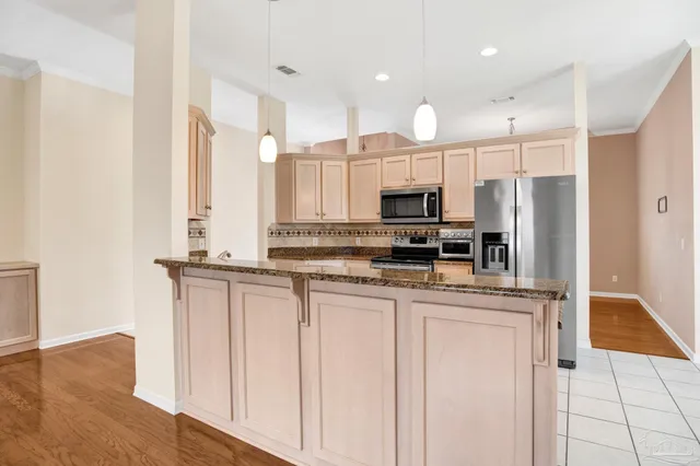 a kitchen with stainless steel appliances granite countertop a refrigerator and a stove top oven