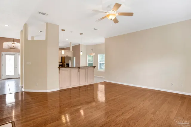 a view of a kitchen with wooden floor and a ceiling fan