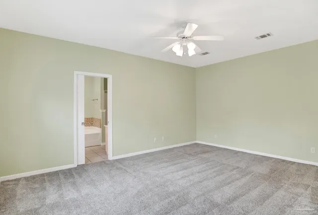 an empty room with a chandelier fan and wooden floor