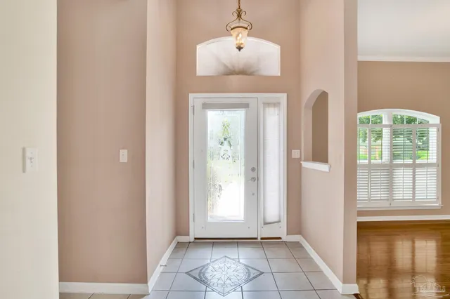 a view of a hallway with windows and chandelier