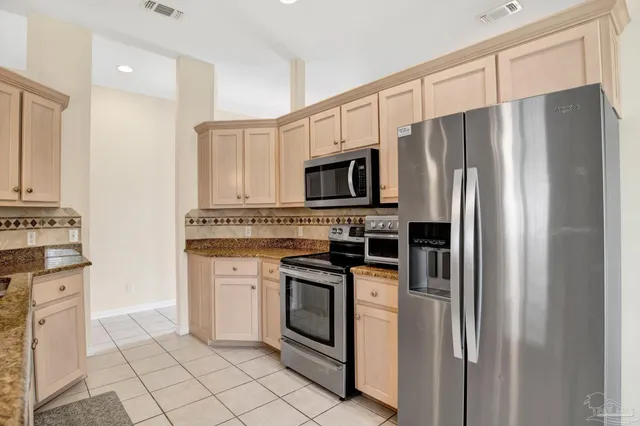 a kitchen with stainless steel appliances a refrigerator sink and microwave