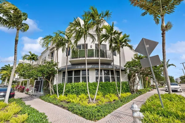 a front view of multi story residential apartment building with yard and green space