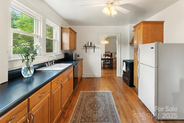 a kitchen with sink a refrigerator and wooden floor