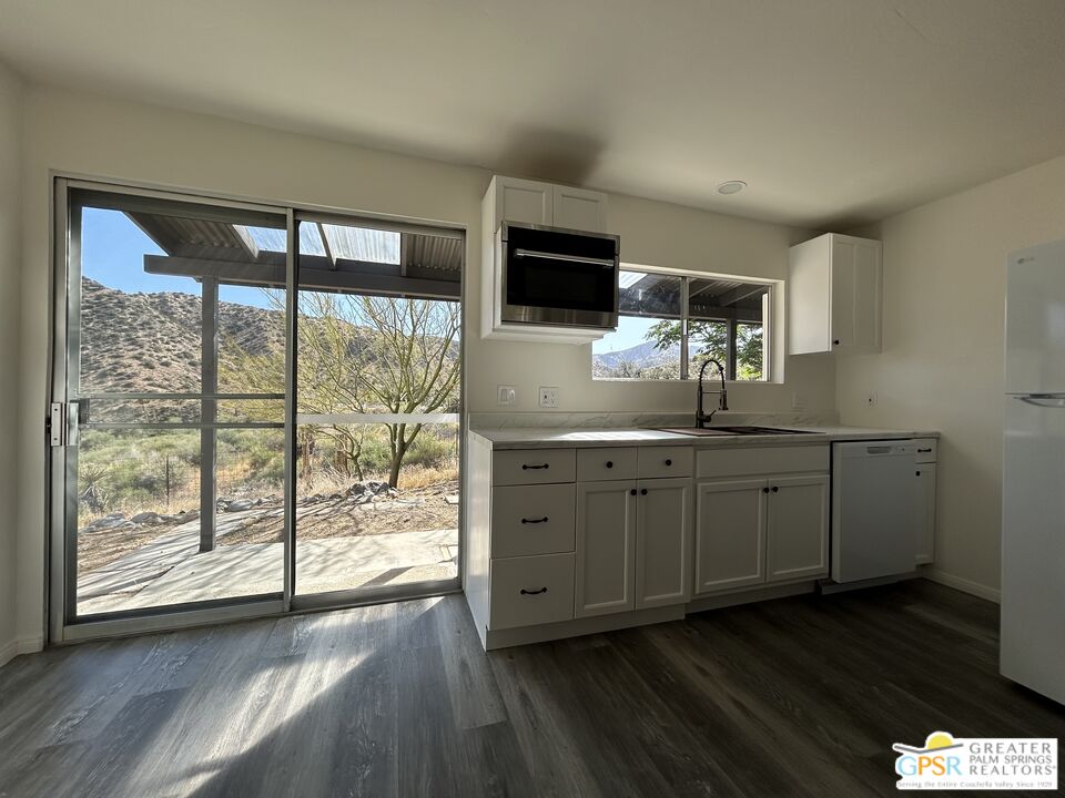 49760 Big Morongo Canyon Road Morongo Valley, CA 92256 - Photo 14 of 47 a kitchen with stainless steel appliances granite countertop a stove a sink and a large window