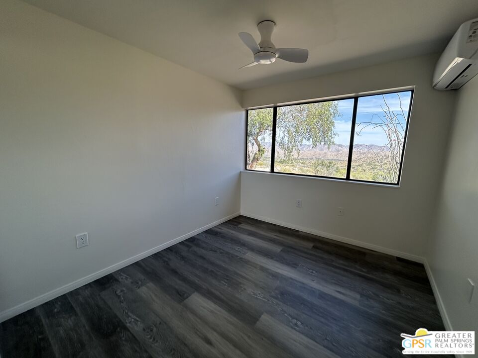 49760 Big Morongo Canyon Road Morongo Valley, CA 92256 - Photo 44 of 47 a view of an empty room with wooden floor and a window