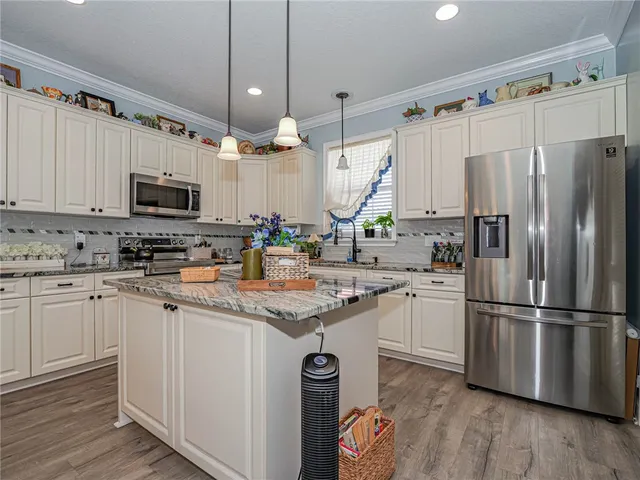 a kitchen with granite countertop a refrigerator stove and microwave