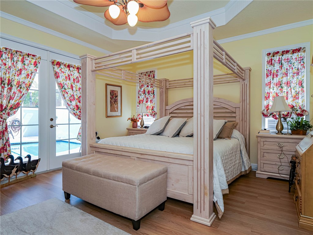 5824 Pine Ridge Circle Vero Beach, FL 32967 - Photo 15 of 34 a bedroom with a bed and a chandelier