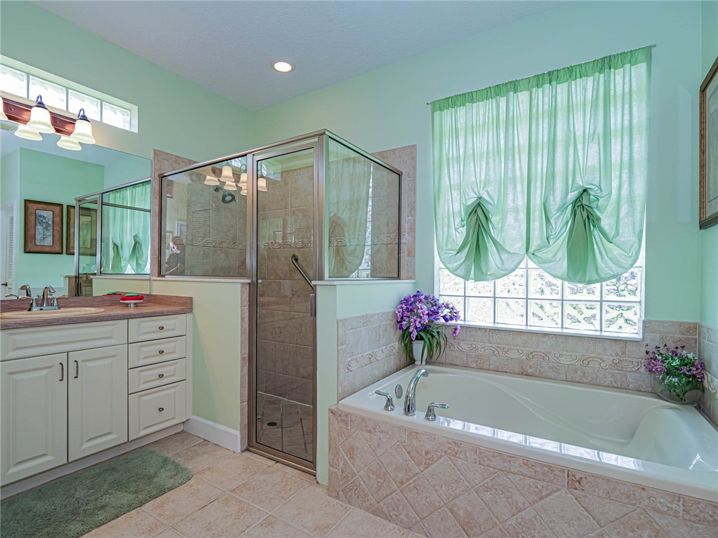 5824 Pine Ridge Circle Vero Beach, FL 32967 - Photo 17 of 34 a bathroom with a tub sink and window