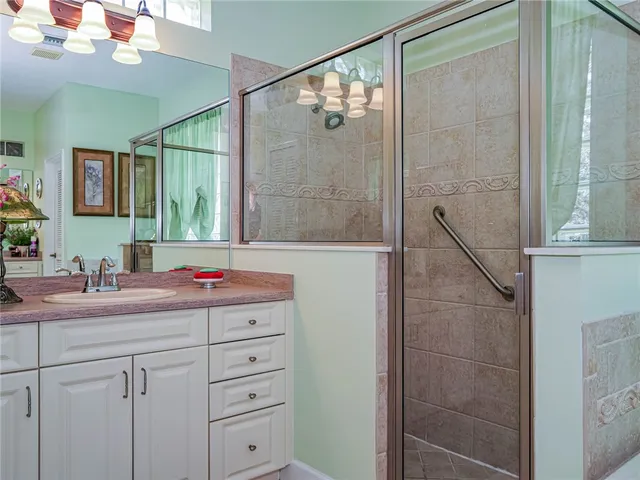 a bathroom with a shower sink and mirror