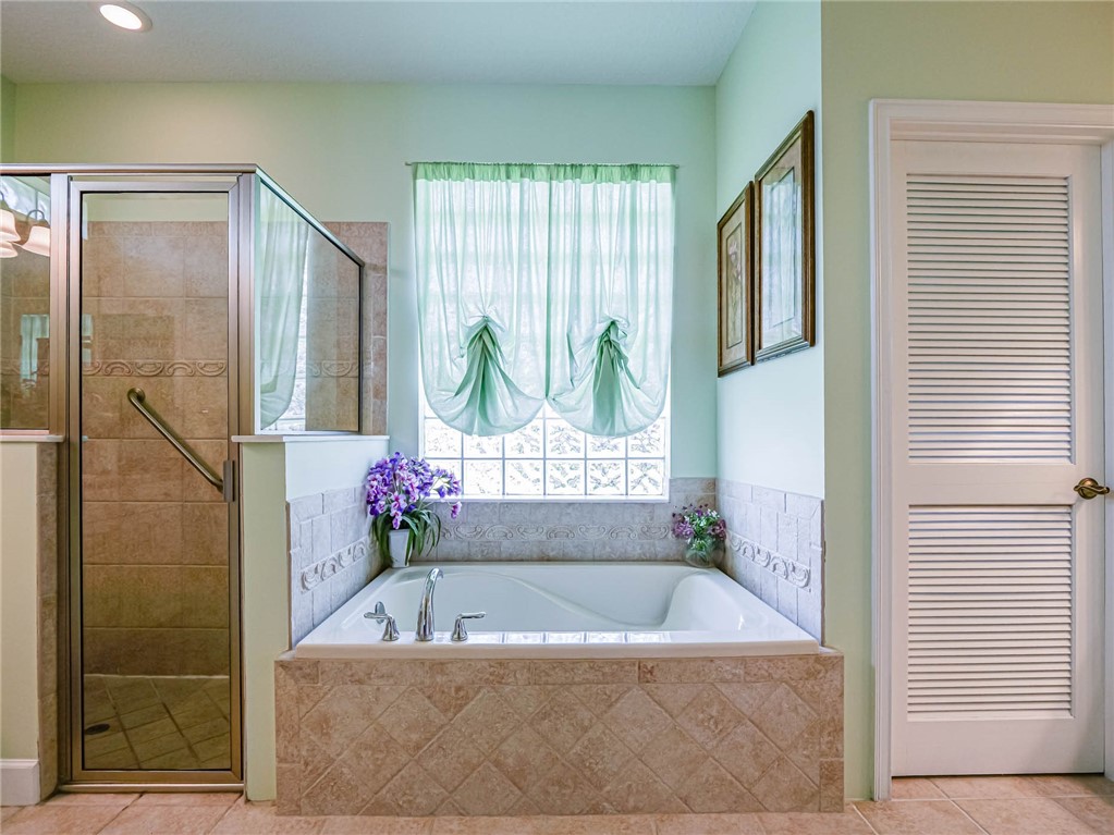 5824 Pine Ridge Circle Vero Beach, FL 32967 - Photo 21 of 34 a bathroom with a tub a window and a shower