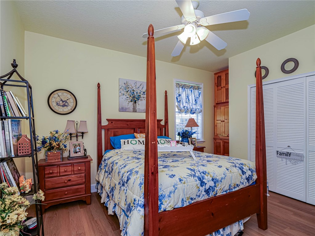 5824 Pine Ridge Circle Vero Beach, FL 32967 - Photo 22 of 34 a bed room with a bed and a chandelier
