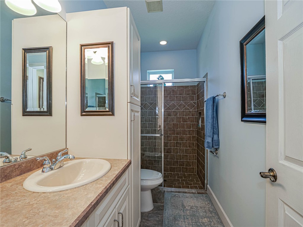 5824 Pine Ridge Circle Vero Beach, FL 32967 - Photo 23 of 34 a bathroom with a granite countertop sink toilet and shower