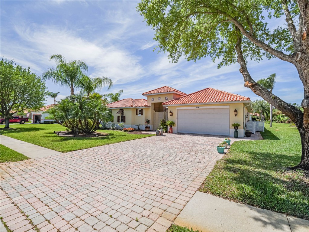 5824 Pine Ridge Circle Vero Beach, FL 32967 - Photo 3 of 34 a front view of a house with a yard and garage
