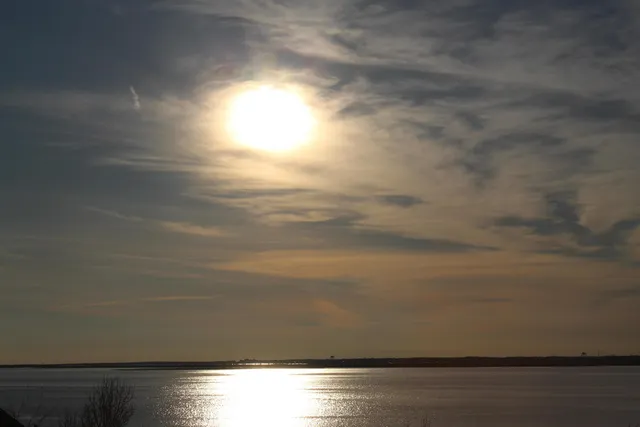 a room with lots of white furniture and a chandelier