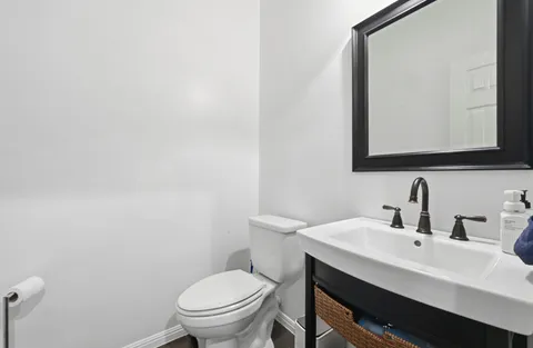 a bathroom with a toilet a sink and mirror