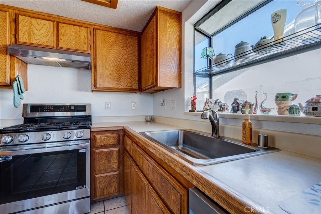 26489 Bluewater Road Helendale, CA 92342 - Photo 12 of 62 a kitchen with stainless steel appliances a stove a sink and a microwave