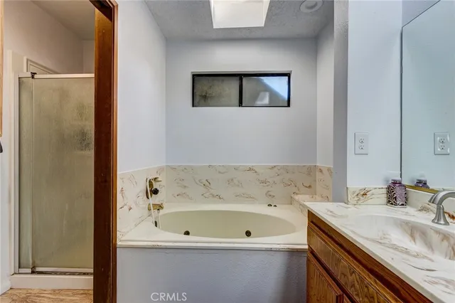 a bathroom with a tub a sink and mirror