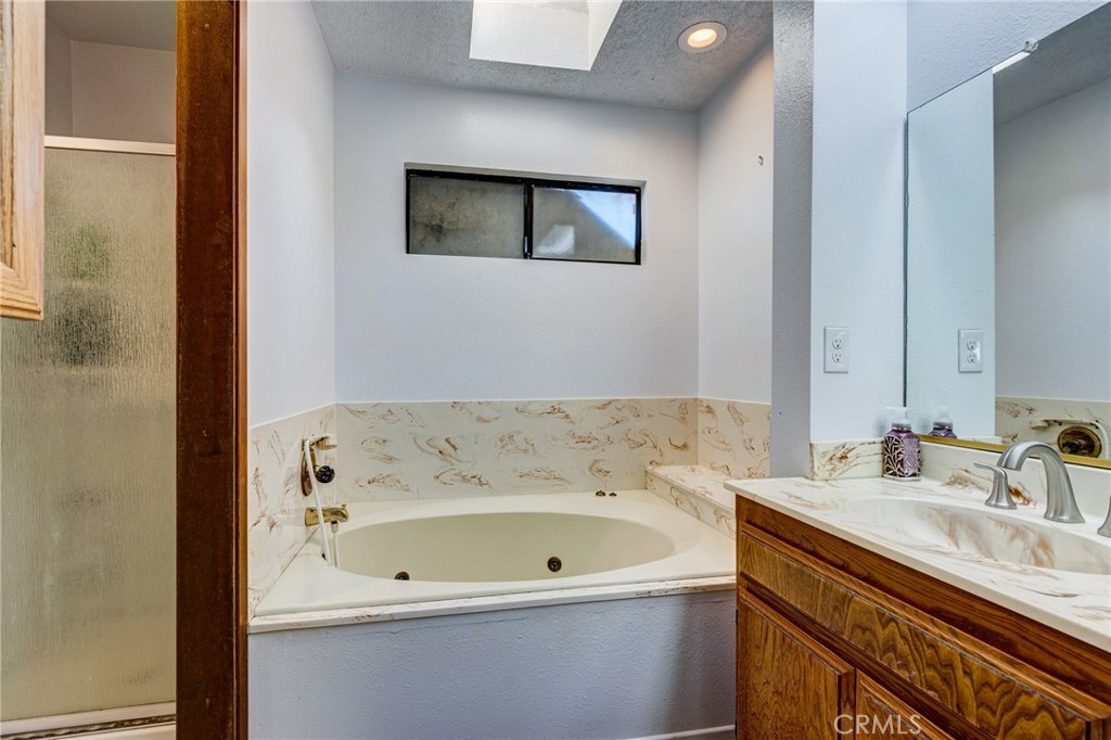 26489 Bluewater Road Helendale, CA 92342 - Photo 29 of 62 a bathroom with a tub a sink and mirror