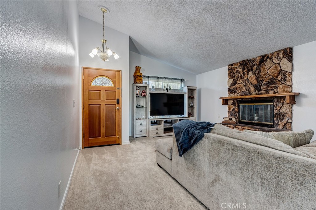 26489 Bluewater Road Helendale, CA 92342 - Photo 9 of 62 a living room with furniture a flat screen tv and a fireplace