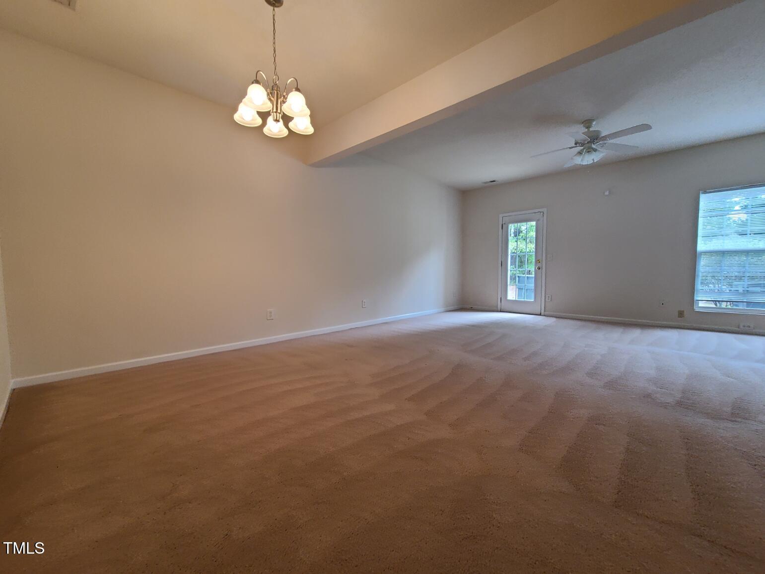 116 Hidden Springs Drive Durham, NC 27703 - Photo 6 of 19 an empty room with windows and chandelier