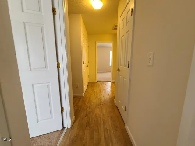 a view of a hallway with wooden floor