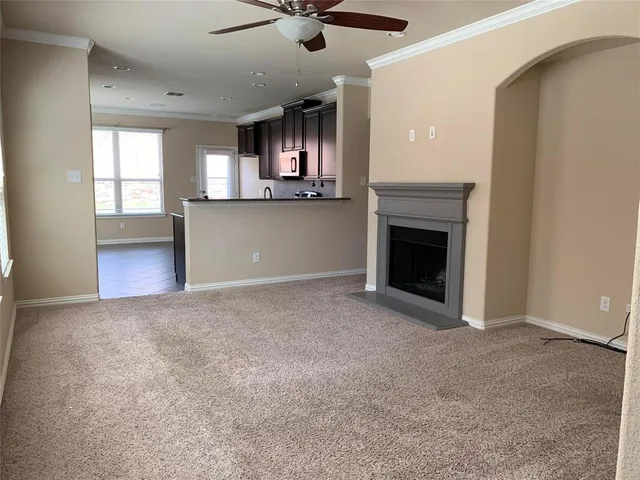 an empty room with windows and fireplace