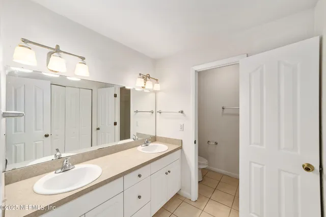 a bathroom with a sink shower and a mirror