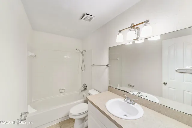 an empty room with windows and ceiling fan