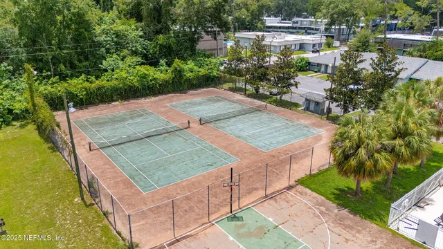 an empty room with chandelier fan and windows