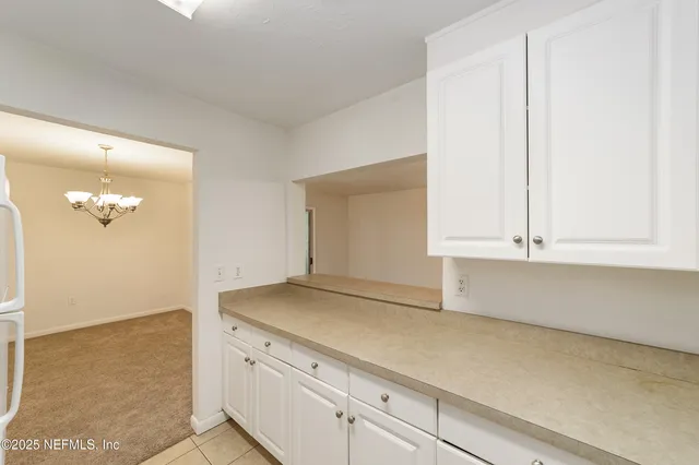 an empty room with windows and chandelier fan
