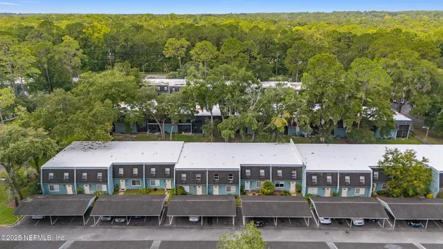 an empty room with chandelier fan and windows