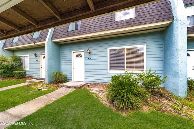 a view of a kitchen with a sink stainless steel appliances and chandelier