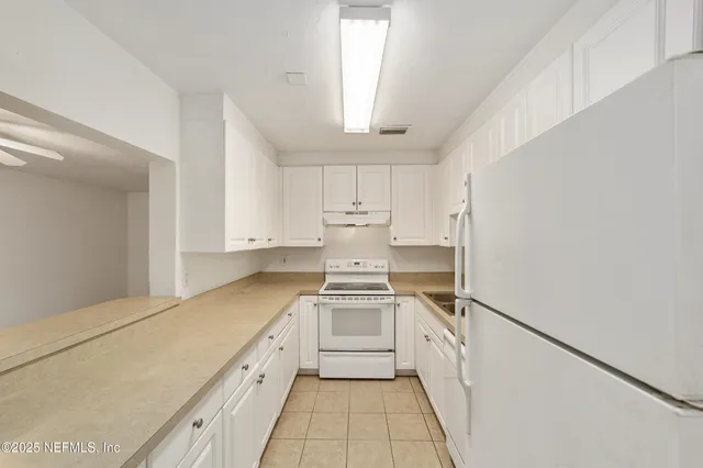 a kitchen with white cabinets and white appliances