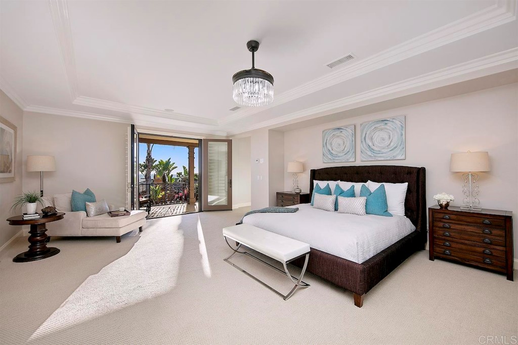 3220 Sitio Montecillo Carlsbad, CA 92009 - Photo 21 of 48 a spacious bedroom with a bed a chandelier and a couch