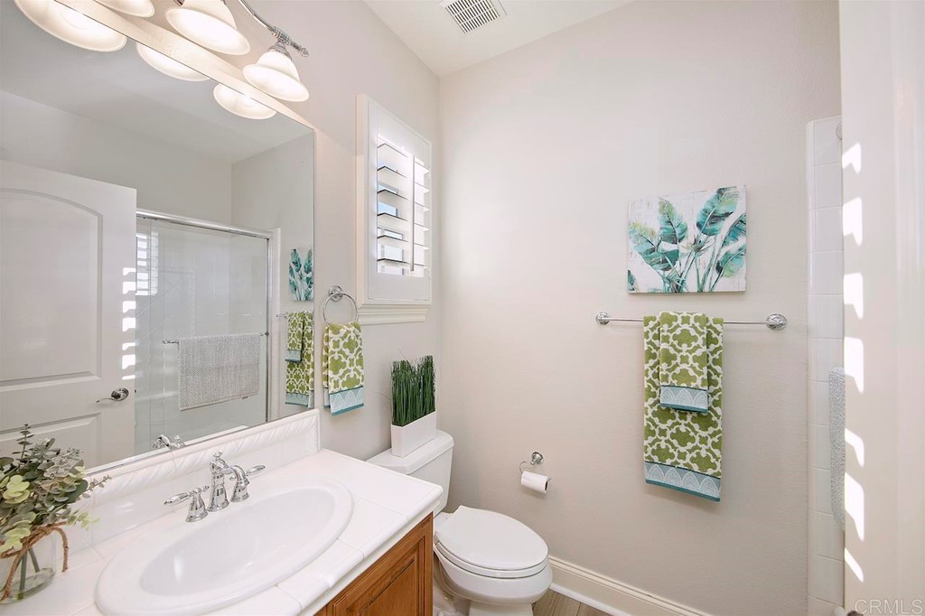 3220 Sitio Montecillo Carlsbad, CA 92009 - Photo 30 of 48 a bathroom with a toilet sink and mirror