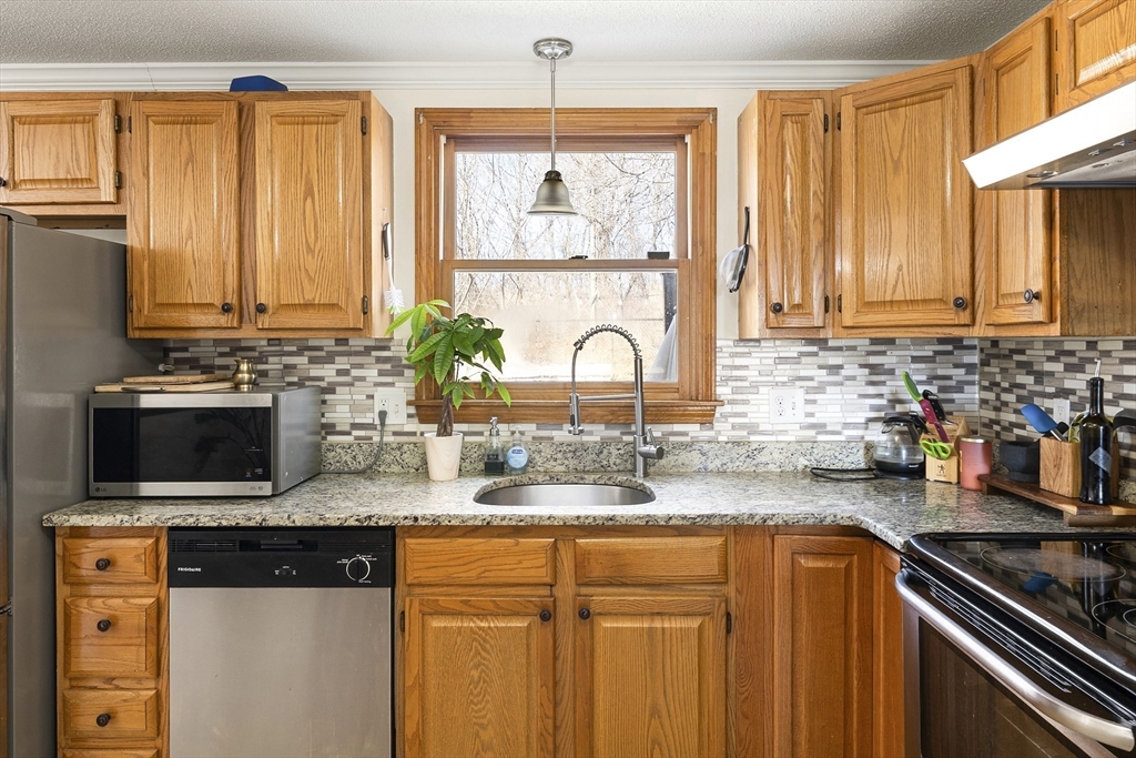 7 Overlook Avenue Haverhill, MA 01832 - Photo 9 of 32 a kitchen with stainless steel appliances granite countertop a stove a sink and a microwave