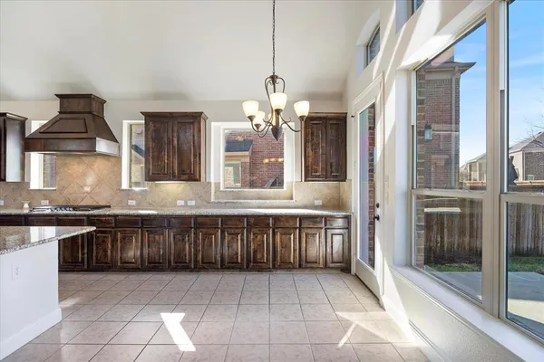 a kitchen with stainless steel appliances granite countertop a sink a stove and a wooden floors
