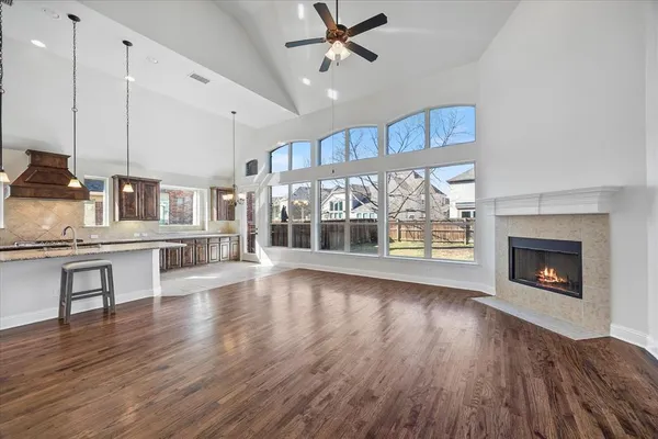 a view of an empty room with wooden floor fireplace and a window