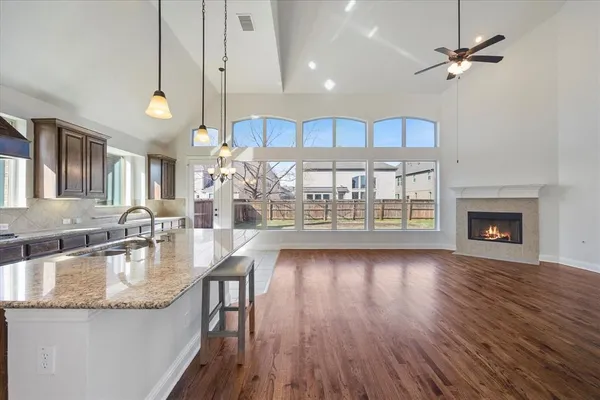 a kitchen with granite countertop a stove a sink and a wooden floors